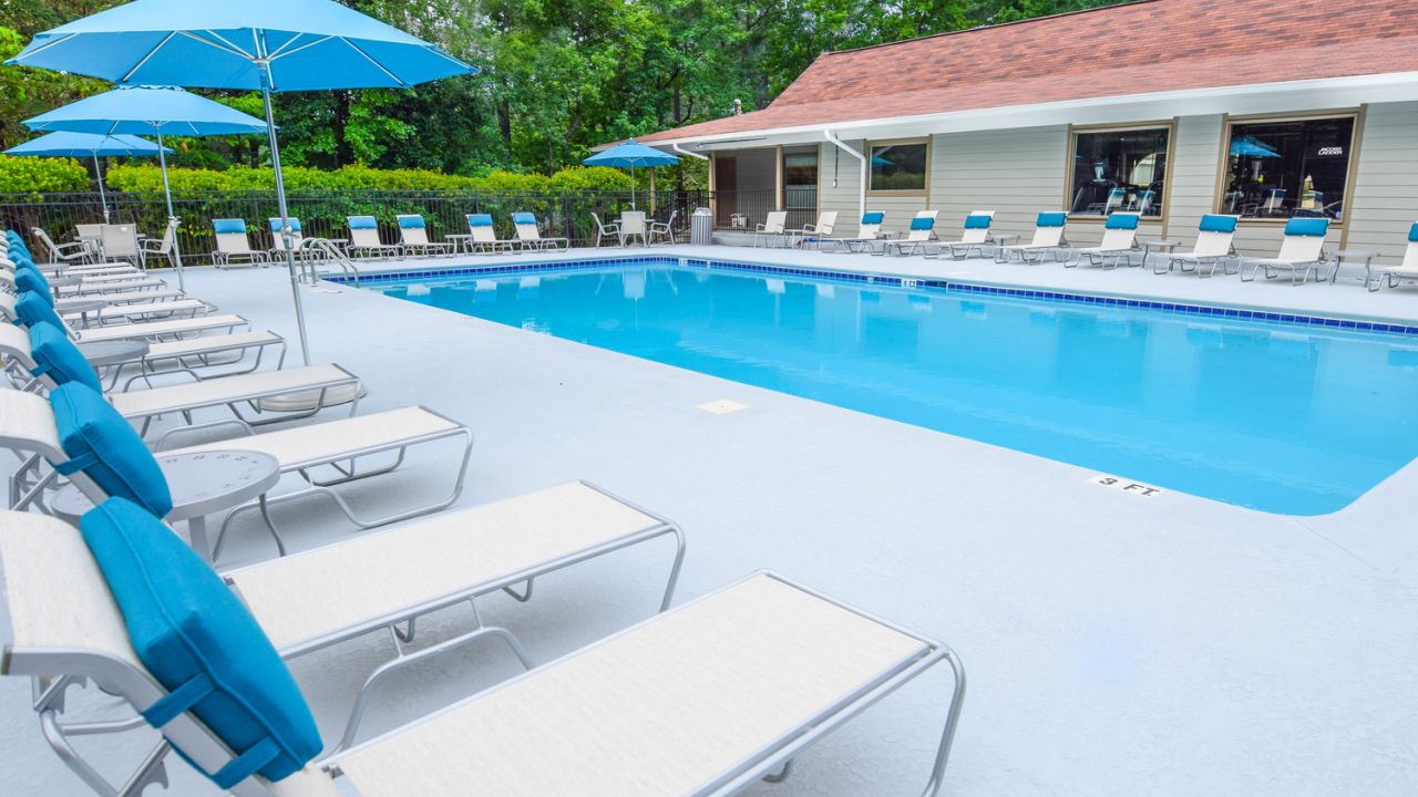 outdoor pool with surrounding seating, tables, and umbrellas